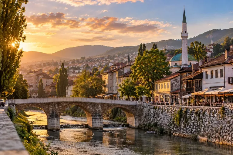 Kameni most preko Miljacke, iza kuće, minaret i brda u zalazu sunca